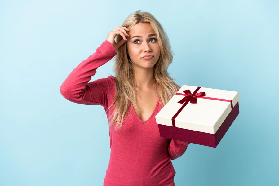 Donna indecisa mentre sceglie un cofanetto regalo beauty