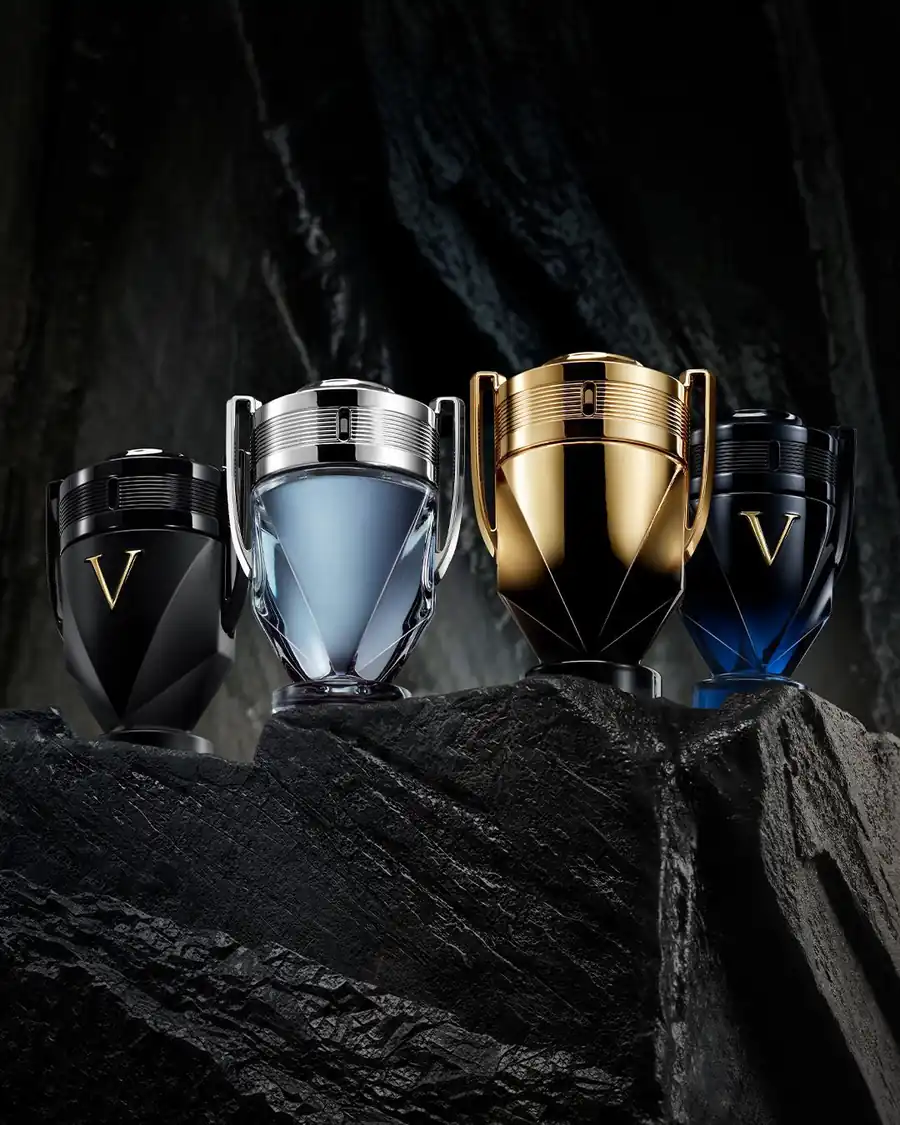 Diverse versioni di profumo Invictus Rabanne esposte su rocce scure